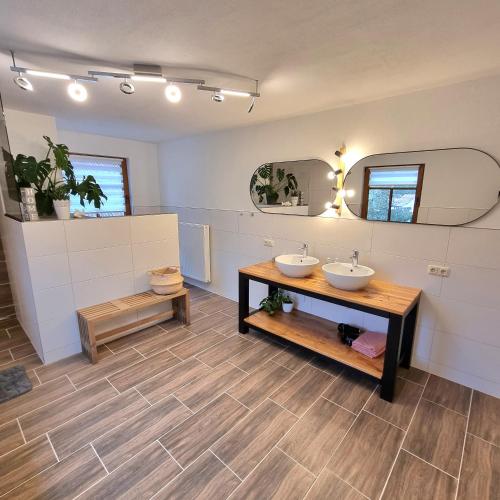 a bathroom with two sinks and two mirrors at Ferienhaus Emma in Bundorf