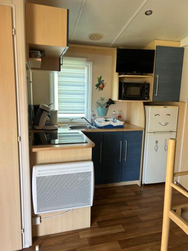 a small kitchen with a sink and a refrigerator at Chez Nathalie mobil home chauffé et climatisé in Boofzheim