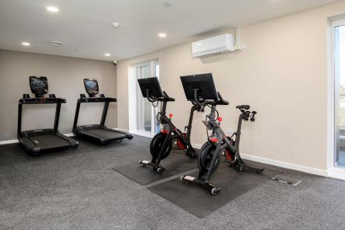 a gym with three exercise bikes in a room at Roomspace Serviced Apartments - Walton Court in Hersham