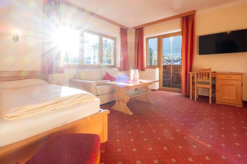 a hotel room with a bed and a couch and a desk at Hotel Rietzer Hof in Rietz