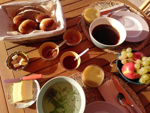 a table topped with bowls of food and cups of coffee at Brin d Ardèche in Lentillères