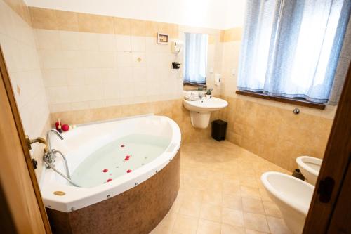 a bathroom with a tub and a toilet and a sink at Rurale Home & Garden in Montella