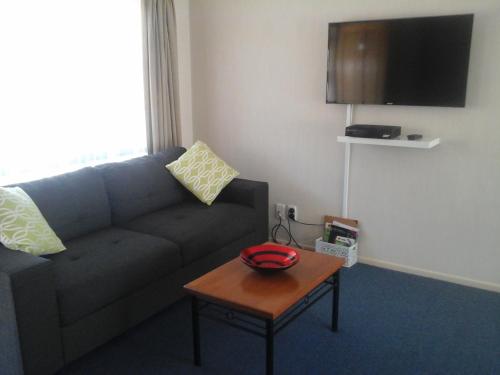a living room with a couch and a table at South Park Motel in Masterton