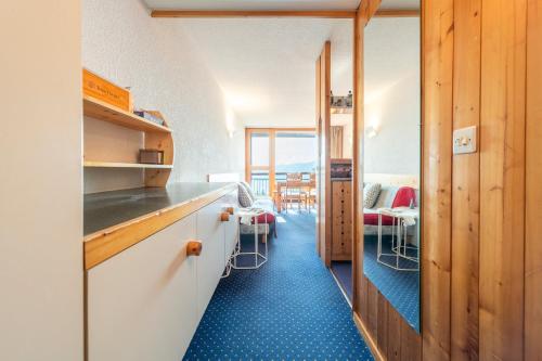 a kitchen with white cabinets and blue flooring at Appartement ambiance cosy Les ARCS 1800 in Arc 1800