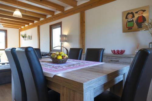 - une table à manger avec des chaises et une corbeille de fruits dans l'établissement CREMANT - Appartement Spacieux et lumineux - Parking gratuit, à Riquewihr
