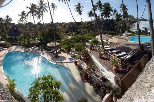 an aerial view of a resort swimming pool with palm trees at SeVi Boutique Hotel in Matemwe