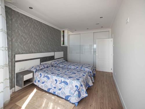 a bedroom with a bed with a blue comforter at Lujo a estrenar con piscina cubierta in Teo