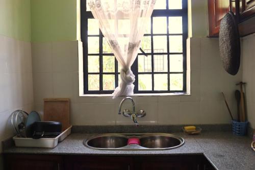 een aanrecht met een wastafel en een raam bij My Moka Arusha in Arusha