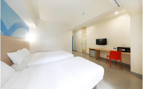 a hotel room with a bed and a red chair at Hop Inn Ortigas Center Manila in Manila