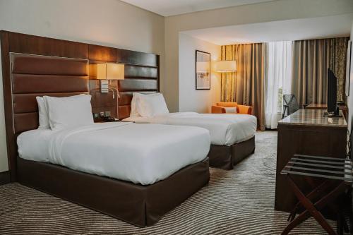a hotel room with two beds and a desk at Hilton Garden Inn, Trivandrum in Trivandrum