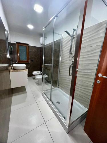 a bathroom with a glass shower and two toilets at Patricia's Apartment in Striano