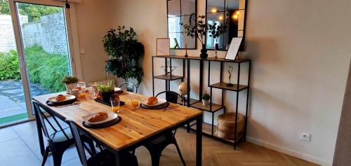 - une table à manger avec des chaises et une table en bois dans l'établissement Le grand Messin - Calais Nord -Cour - Plage - Ferry - Eurotunnel, à Calais