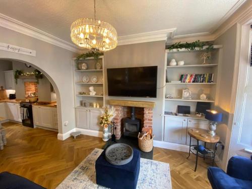 a living room with a fireplace and a flat screen tv at Harbour Heights Whitby in Whitby