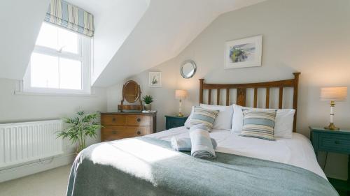 a bedroom with a large white bed with two pillows at Ty Haf in Rhosneigr