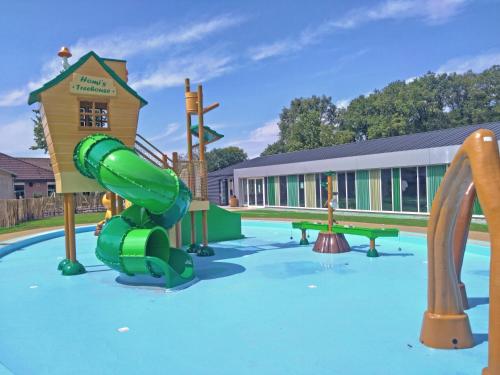 a playground with a green slide in a pool at Camping Marvilla Parks Kaatsheuvel in Kaatsheuvel