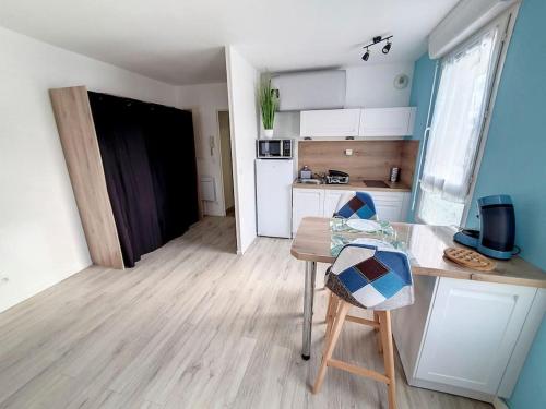 Cette chambre comprend une petite cuisine avec une table et une chaise. dans l'établissement Studio, à Sens