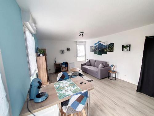 un salon avec une table et un canapé dans l'établissement Studio, à Sens