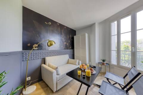 un salon avec un canapé et une table dans l'établissement Appartement chic et moderne, à Aubervilliers