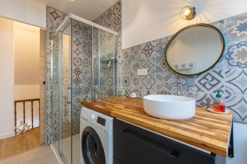une salle de bain avec un lavabo et une machine à laver dans l'établissement La Sirène - Entre châteaux et Beauval, à Romorantin-Lanthenay