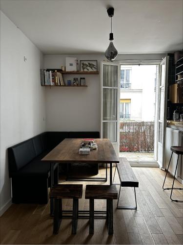 un salon avec une table en bois et un canapé dans l'établissement Art House bastille 2 bed apartment w balcony, 11eme super trendy neighbourhood, à Paris