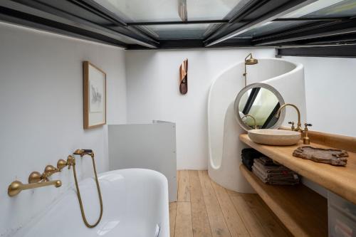 une salle de bain avec une baignoire, un lavabo et un miroir dans l'établissement 2 Élégants Appartements au Cœur du Marais, à Paris