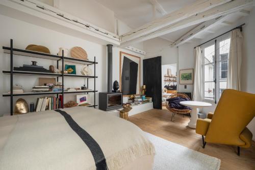 une chambre avec un lit et un salon dans l'établissement 2 Élégants Appartements au Cœur du Marais, à Paris