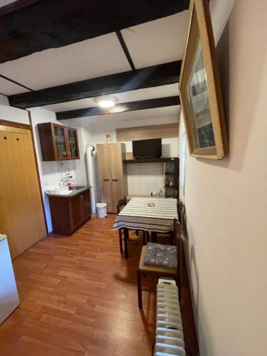 a small room with a table and a kitchen at Dedina kuća 1937 in Mokra Gora