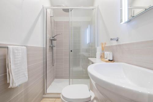 a bathroom with a shower and a toilet and a sink at King Deluxe Ensuite with Courtyard View - Hawking in Cambridge
