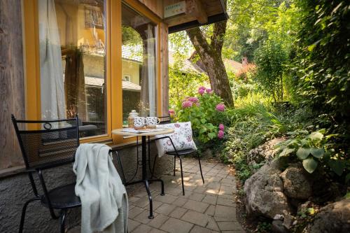 un patio con mesa y sillas frente a una ventana en Alpine styled apartment in central BLED, en Bled