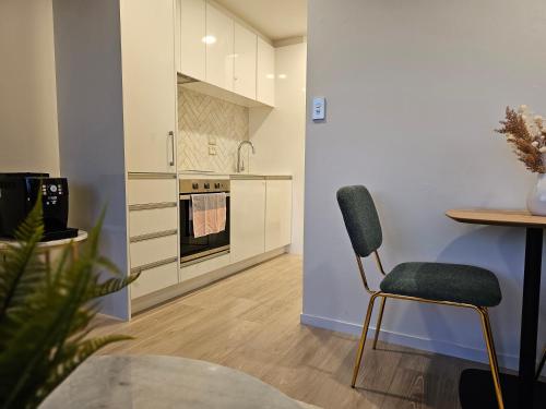 a kitchen with a table and a chair in a room at Urban Retreat - Central Auckland Stay in Auckland