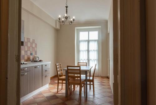 a kitchen with a table and chairs and a window at Apartments Torino Porta Susa PLUS in Turin
