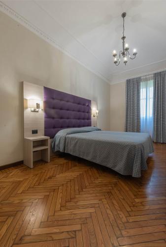 a bedroom with a large bed with a purple headboard at Apartments Torino Porta Susa PLUS in Turin