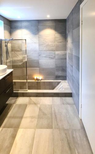 a bathroom with a shower and a sink and a tub at Villa with a view in Ålesund