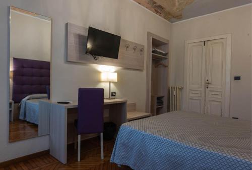 a bedroom with a bed and a desk with a computer at Apartments Torino Porta Susa PLUS in Turin
