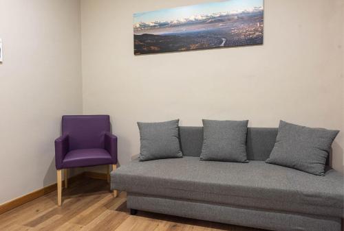 a couch and a purple chair in a room at Apartments Torino Porta Susa PLUS in Turin