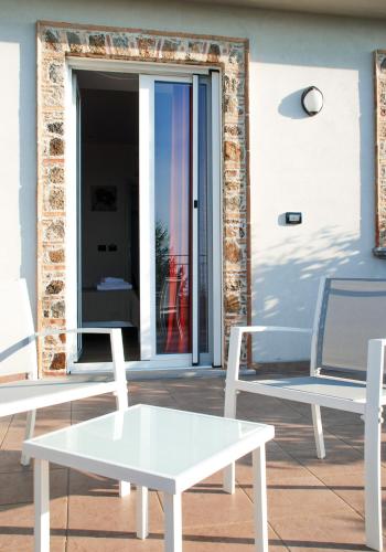 two white chairs and a table in front of a door at B&B Il Giardino di Circe - Filadelfia (VV) in Filadelfia