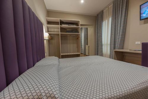 a bedroom with a large bed with purple walls at Apartments Torino Porta Susa PLUS in Turin