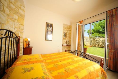 a bedroom with a bed with a yellow blanket at Elya in Prínos
