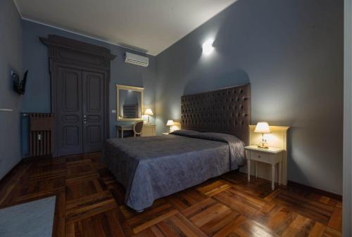 a bedroom with a bed and two tables and a door at Apartments Torino Porta Susa PLUS in Turin