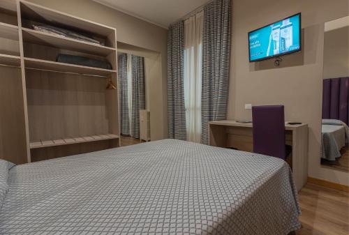 a bedroom with a bed and a tv on the wall at Apartments Torino Porta Susa PLUS in Turin