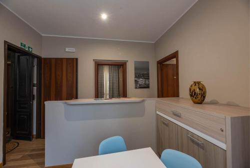 a kitchen with a counter and blue chairs in it at Apartments Torino Porta Susa PLUS in Turin