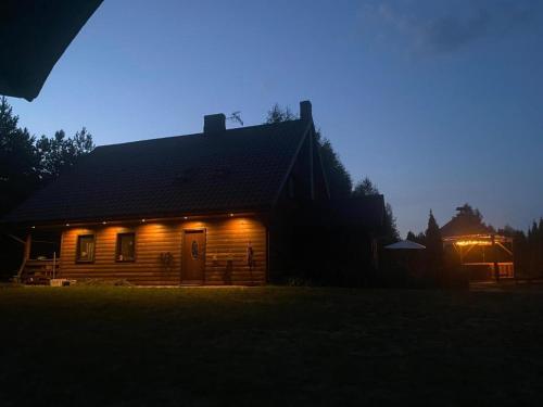 a house lit up at night with lights on it at Agroturystyka Szczebra 33c Dolina Rospudy pod Augustowem, Apartamenty 2-pokojowe z aneksami kuchennymi in Augustów