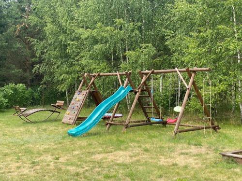 a playground with two swings and a slide at Agroturystyka Szczebra 33c Dolina Rospudy pod Augustowem, Apartamenty 2-pokojowe z aneksami kuchennymi in Augustów