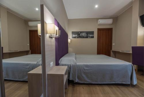 a hotel room with two beds and a mirror at Apartments Torino Porta Susa PLUS in Turin