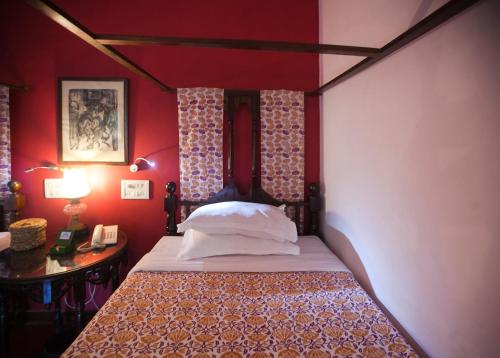 a bedroom with a bed with red walls at Presa di Goa - Managed by Smith and Appy in Calangute
