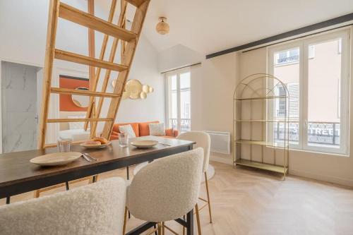 une salle à manger avec une table et quelques chaises dans l'établissement Maison proche Atelier des Lumieres Rue Oberkampf, à Paris