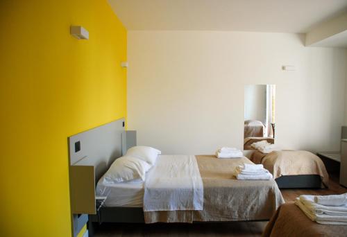a room with two beds with yellow walls at B&B Il Giardino di Circe - Filadelfia (VV) in Filadelfia