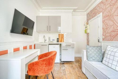 - une cuisine blanche avec une table et un canapé dans l'établissement Green apartment Paris city center - III, à Paris