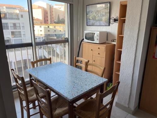 Cette chambre dispose d'un balcon avec une table et des chaises. dans l'établissement Cap près port commerces, au Cap d'Agde