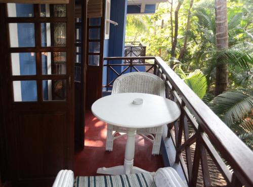 a white table and chair on a balcony at Presa di Goa - Managed by Smith and Appy in Calangute